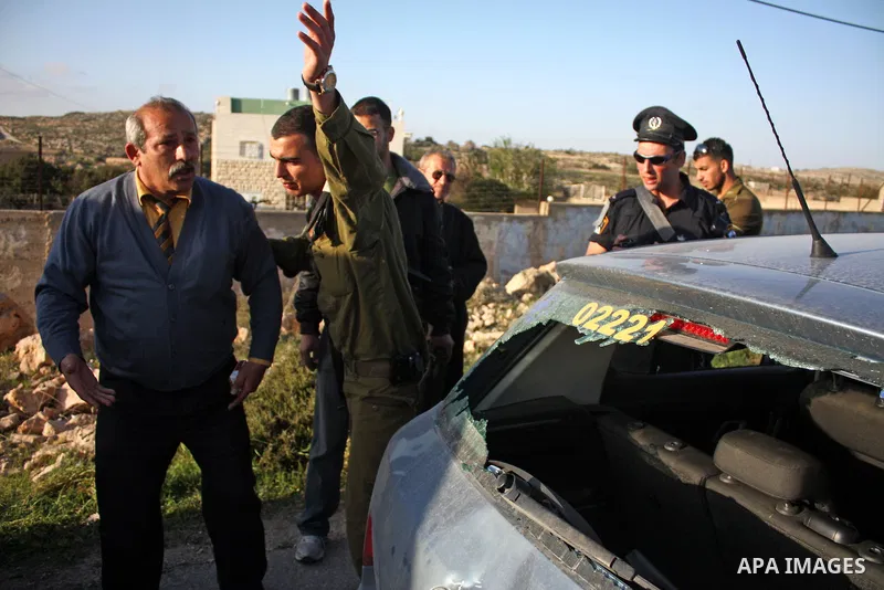 A Palestinian man gestures near his damaged car after Jewish settlers from the Kharsina settlement threw stones at Palestinian drivers on March 21,2011 near Hebron in the Israeli-occupied West Bank, as three Palestinians...
