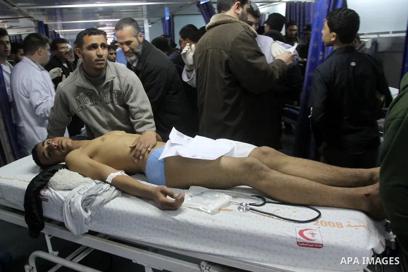 Palestinian medics stand next to a Palestinian injured in an Israeli shells, after was brought to the Shifa hospital in Gaza City, Tuesday, March 22, 2011. Israeli tank fire struck a house in the Gaza Strip on Tuesday, k...