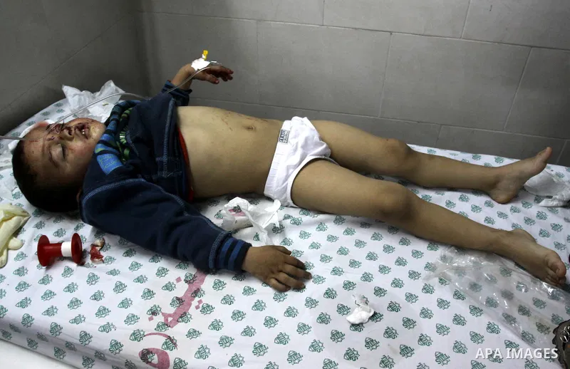 Palestinian medics stand next to a Palestinian injured in an Israeli shells, after was brought to the Shifa hospital in Gaza City, Tuesday, March 22, 2011. Israeli tank fire struck a house in the Gaza Strip on Tuesday, k...
