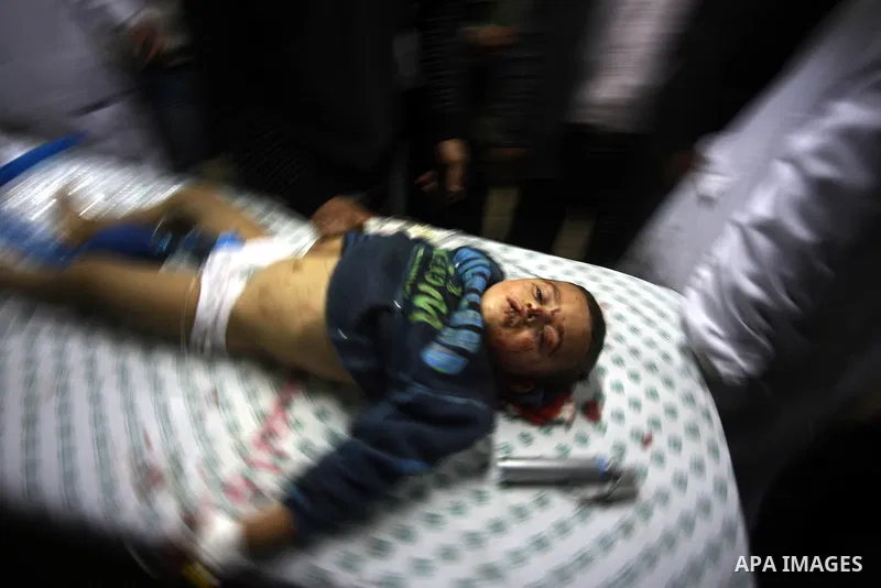 Palestinian medics stand next to a Palestinian injured in an Israeli shells, after was brought to the Shifa hospital in Gaza City, Tuesday, March 22, 2011. Israeli tank fire struck a house in the Gaza Strip on Tuesday, k...
