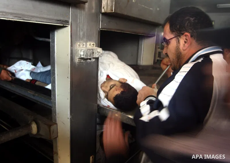 Palestinians mourn next to the body of a Palestinian killed in an Israeli shells, after was brought to the morgue of Shifa hospital in Gaza City, Tuesday, March 22, 2011. Israeli tank fire struck a house in the Gaza Stri...