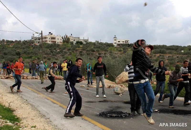 Palestinian youths throw stones at Israeli border police during clashes outside the West Bank Palestinian village of Awarta near Nablus March 22, 2011. Israeli troops have been operating in the area since the fatal stabb...