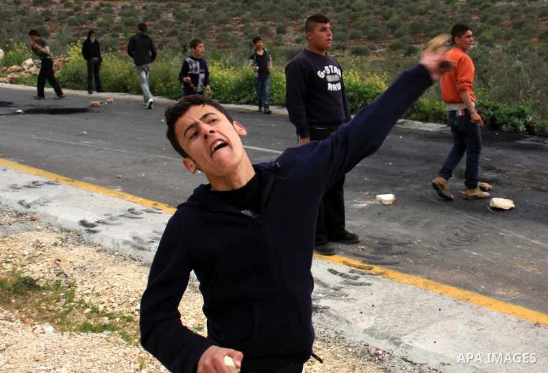 Palestinian youths throw stones at Israeli border police during clashes outside the West Bank Palestinian village of Awarta near Nablus March 22, 2011. Israeli troops have been operating in the area since the fatal stabb...