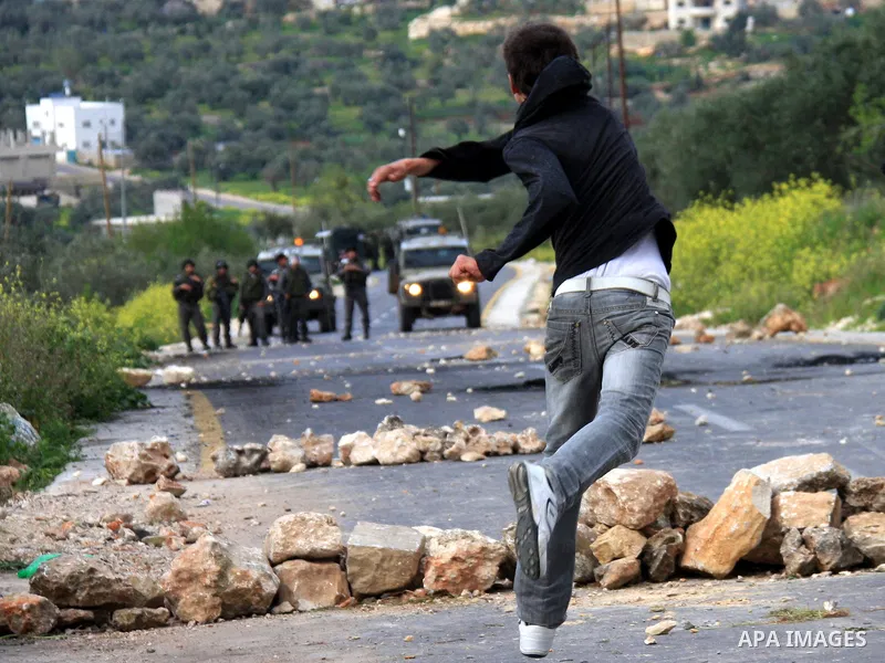 Palestinian youths throw stones at Israeli border police during clashes outside the West Bank Palestinian village of Awarta near Nablus March 22, 2011. Israeli troops have been operating in the area since the fatal stabb...
