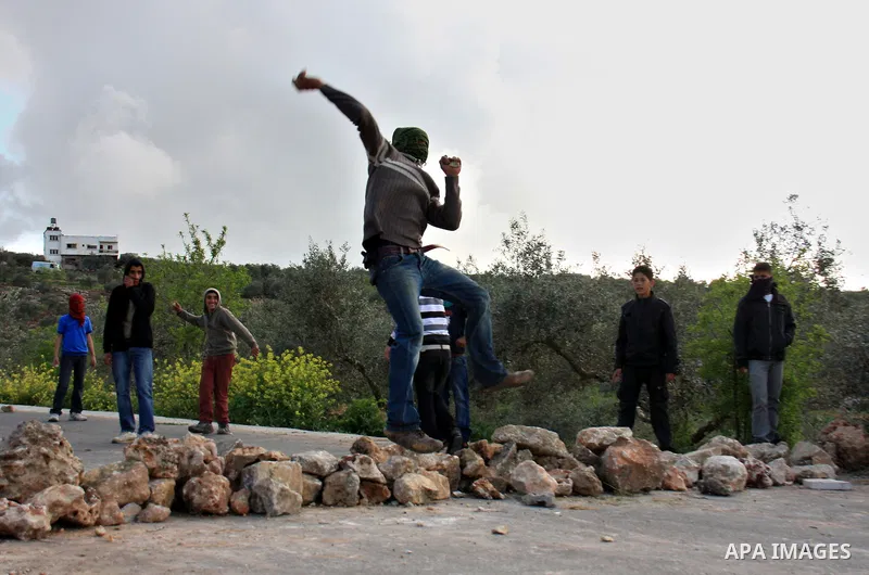 Palestinian youths throw stones at Israeli border police during clashes outside the West Bank Palestinian village of Awarta near Nablus March 22, 2011. Israeli troops have been operating in the area since the fatal stabb...