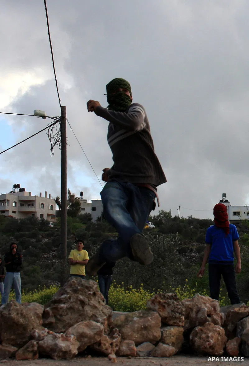 Palestinian youths throw stones at Israeli border police during clashes outside the West Bank Palestinian village of Awarta near Nablus March 22, 2011. Israeli troops have been operating in the area since the fatal stabb...
