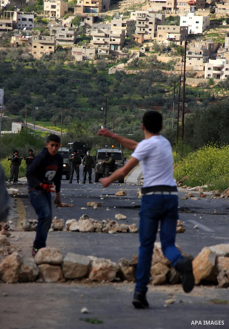 Palestinian youths throw stones at Israeli border police during clashes outside the West Bank Palestinian village of Awarta near Nablus March 22, 2011. Israeli troops have been operating in the area since the fatal stabb...