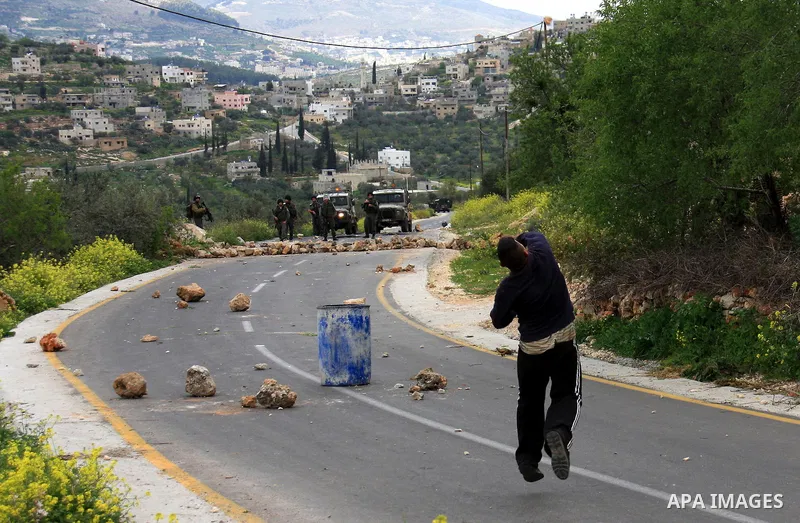 Palestinian youths throw stones at Israeli border police during clashes outside the West Bank Palestinian village of Awarta near Nablus March 22, 2011. Israeli troops have been operating in the area since the fatal stabb...