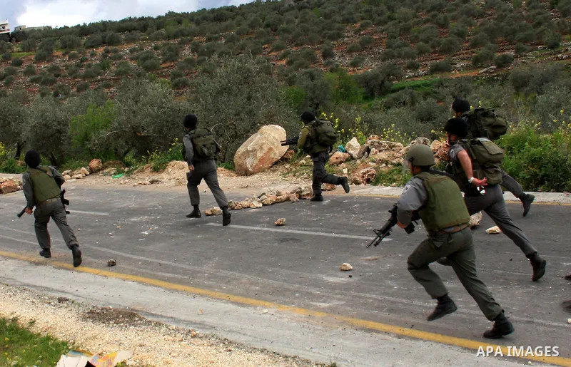 Israeli border policemen run towards Palestinian stone-throwers during clashes outside the West Bank Palestinian village of Awarta, near Nablus March 22, 2011. Israeli troops have been operating in the area since the fat...