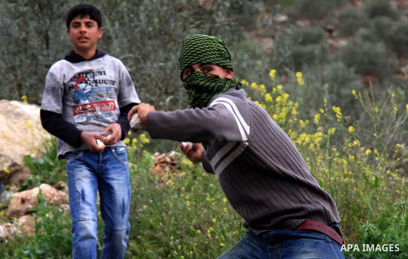 Palestinian youths throw stones at Israeli border police during clashes outside the West Bank Palestinian village of Awarta near Nablus March 22, 2011. Israeli troops have been operating in the area since the fatal stabb...