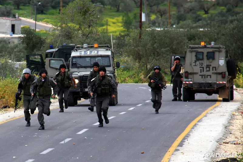 Israeli border policemen run towards Palestinian stone-throwers during clashes outside the West Bank Palestinian village of Awarta, near Nablus March 22, 2011. Israeli troops have been operating in the area since the fat...