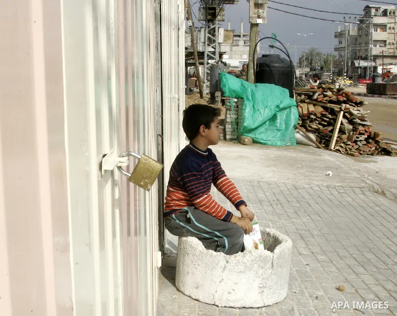 Palestinians walk in front of closed shops at Rafah, southern Gaza Strip, as the Palestinian government in Gaza announced Wednesday, a day of mourning for the lives of eight martyrs killed yesterday in the Israeli raids...