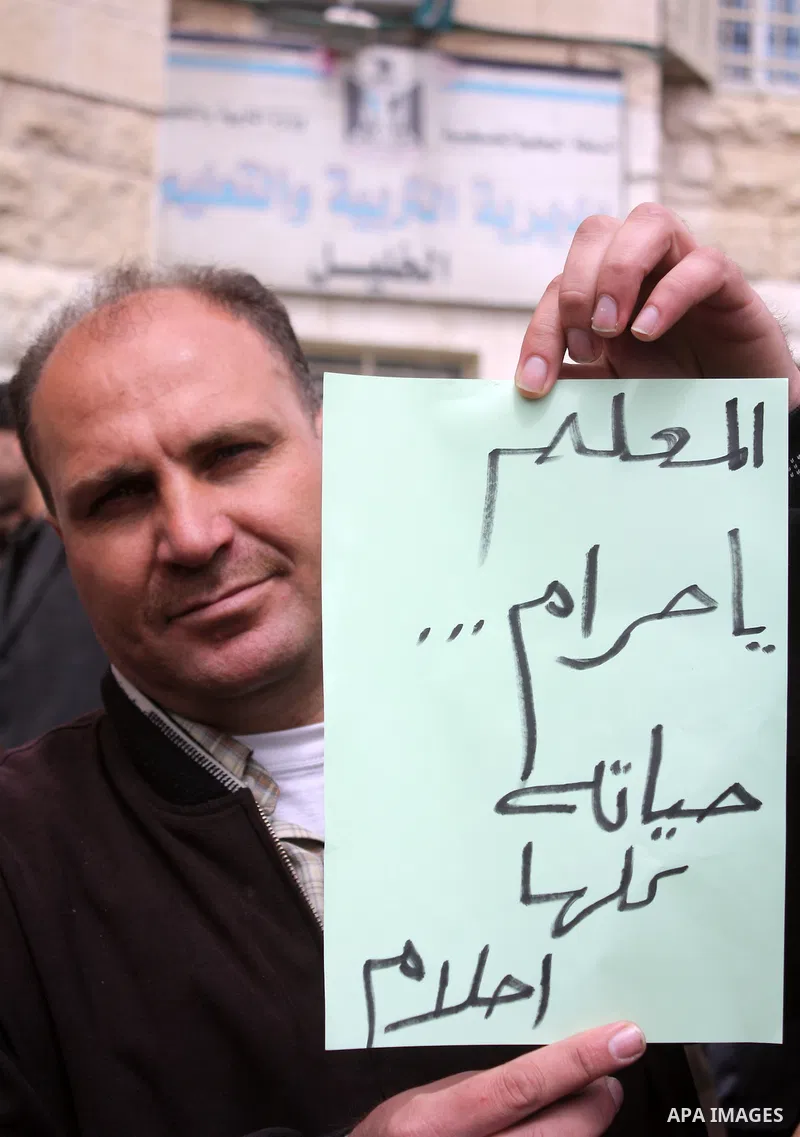 Palestinian teachers take part in a demonstration outside the office of the Directorate of Education in the West Bank city of Hebron on March 23 ,2011. Photo by Najeh Hashlamoun.