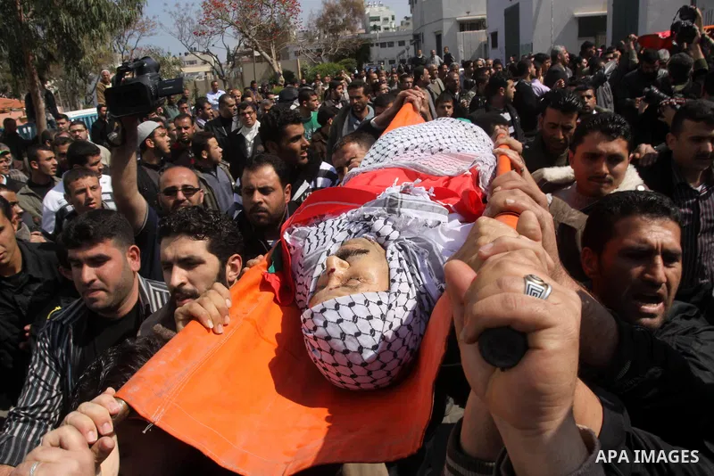 Palestinian mourners carry the bodies of Palestinians during a funeral in Al-Shjaea eastern Gaza City, Gaza Strip, 23 March, 2011 a day after eight Gazans were killed, among them two minors and four militants, as tension...