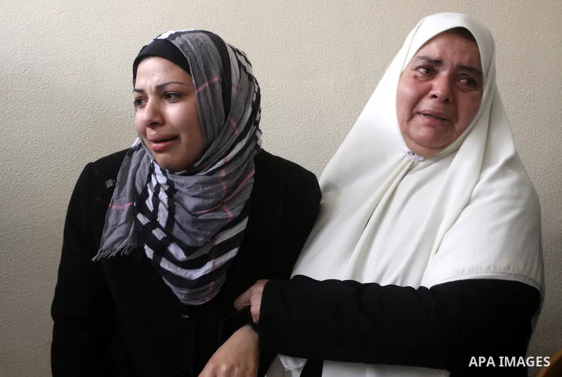 Palestinian women mourn at the bodies of Palestinians during their funeral in Gaza City, Gaza Strip, 23 March, 2011 a day after eight Gazans were killed, among them two minors and four militants, as tensions soared on th...