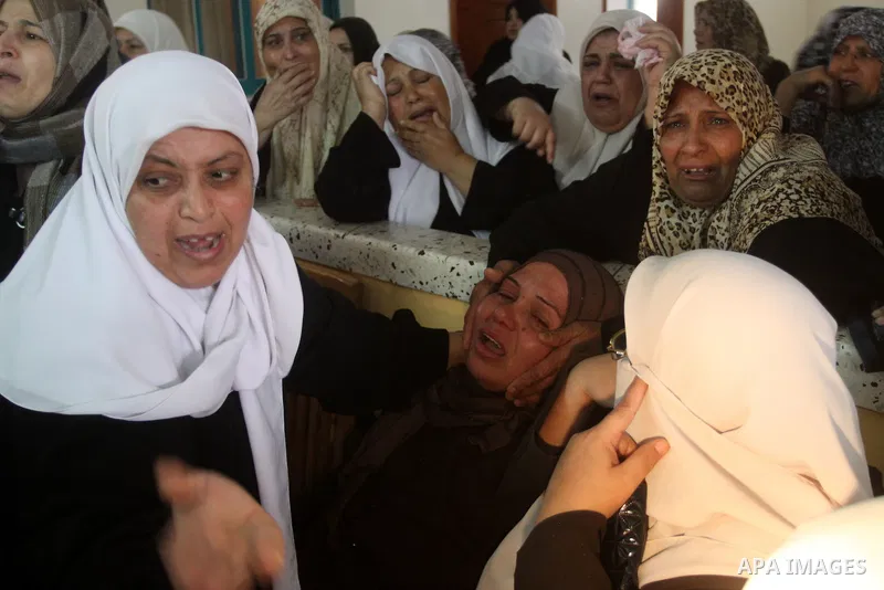 Palestinian women mourn at the bodies of Palestinians during their funeral in Gaza City, Gaza Strip, 23 March, 2011 a day after eight Gazans were killed, among them two minors and four militants, as tensions soared on th...