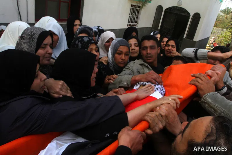 Palestinian women mourn at the bodies of Palestinians during their funeral in Gaza City, Gaza Strip, 23 March, 2011 a day after eight Gazans were killed, among them two minors and four militants, as tensions soared on th...