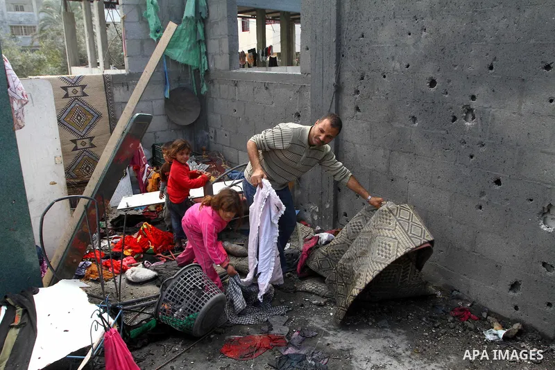 Palestinians survey the scene after Israeli tank fire struck a home in Gaza City March 23, 2011. Israeli air strikes and shelling killed nine Palestinians in the Gaza Strip on Tuesday, medical officials said, in the dead...