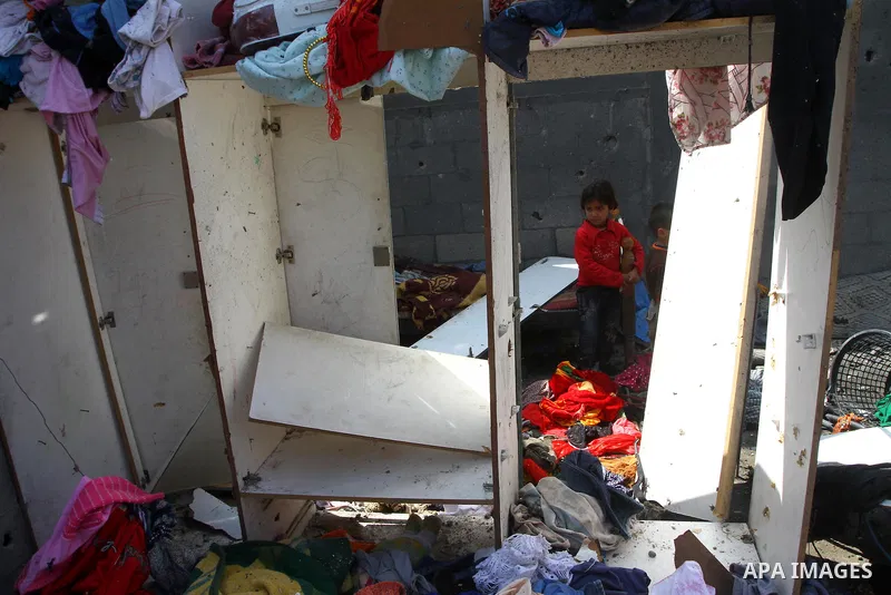 Palestinians survey the scene after Israeli tank fire struck a home in Gaza City March 23, 2011. Israeli air strikes and shelling killed nine Palestinians in the Gaza Strip on Tuesday, medical officials said, in the dead...
