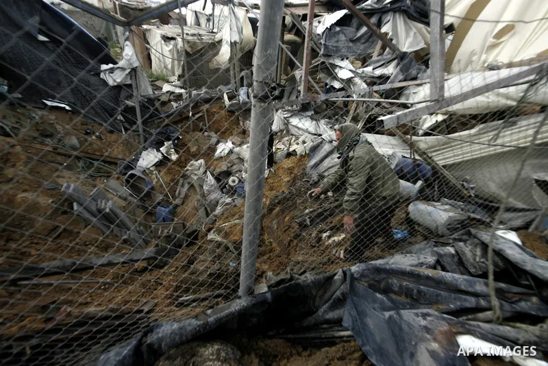 Palestinians survey the damage after an Israeli air strike on a smuggling tunnel in the southern Gaza Strip, along the Gaza-Egypt border March 24, 2011. Israeli aircraft struck targets in the Gaza Strip on Thursday, a da...