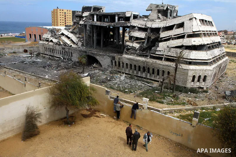 Palestinians observe the destroyed security office in Gaza City, on March 25, 2011, as Israeli aircraft attacked four targets in the Gaza Strip during the night, lightly wounding three people, in response to Palestinian...