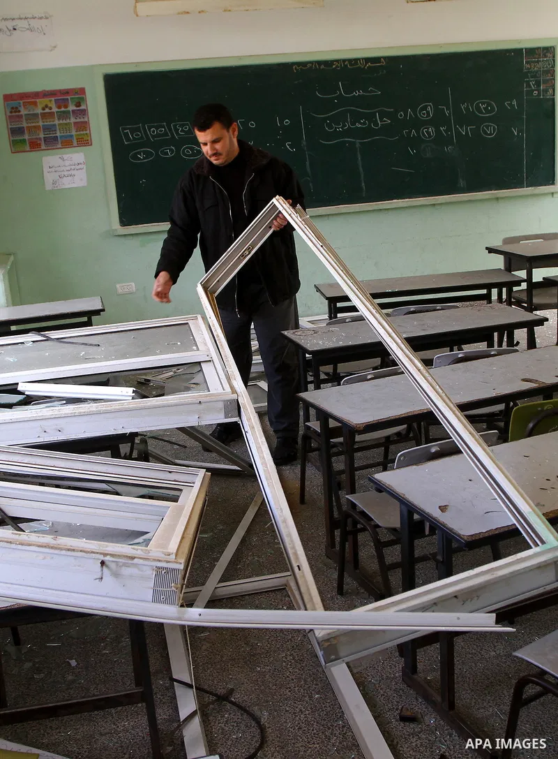 Palestinian man inspects the damage at a school near the destroyed security office in Gaza City, on March 25, 2011, as Israeli aircraft attacked four targets in the Gaza Strip during the night, lightly wounding three peo...