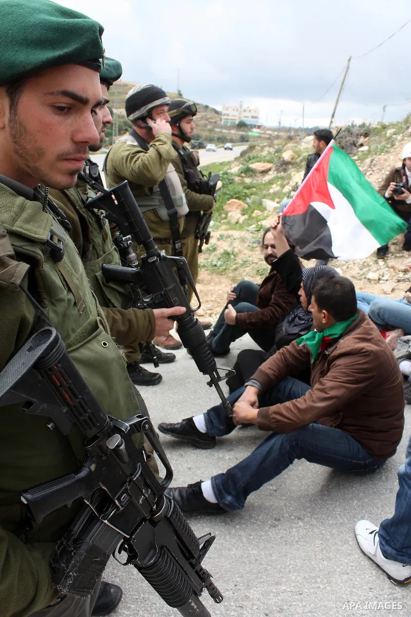Protesters argue with an Israeli soldier during a demonstration against Israel's controversial separation barrier in the West Bank village of Maasarah, near the biblical town of Bethlehem on March 25, 2011.Israel says th...