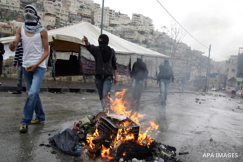 Palestinian youths hurl stones towards Israeli border police during clashes in the mostly Arab neighborhood of Silwan in East Jerusalem March 25, 2011. Photo by Mahfouz Abu Turk .