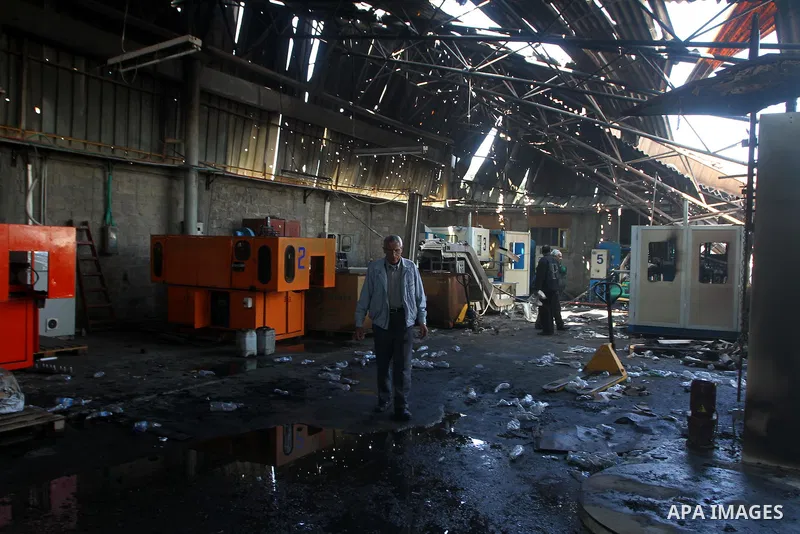 Palestinians observe the damage in a soft drinks factory after an explosion earlier on March 26, 2011 in the Zeitun neighbourhood of Gaza city. Despite Israel military said none of its forces were operating in the area,...