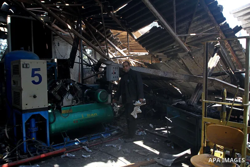 Palestinians observe the damage in a soft drinks factory after an explosion earlier on March 26, 2011 in the Zeitun neighbourhood of Gaza city. Despite Israel military said none of its forces were operating in the area,...