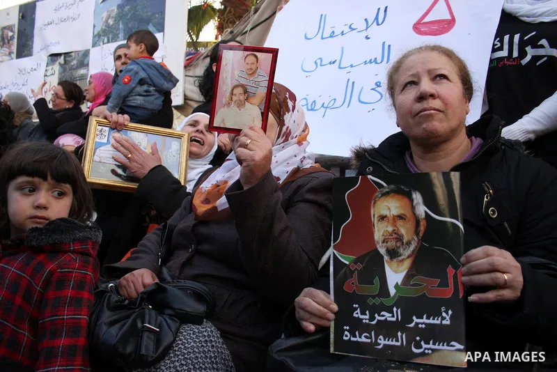 Palestinians hold pictures of their prisoned relatives in Israeli jails as they gather in a protest calling for their liberty in the West Bank city of Ramallah on March 26,2011. Photo by Issam Rimawi