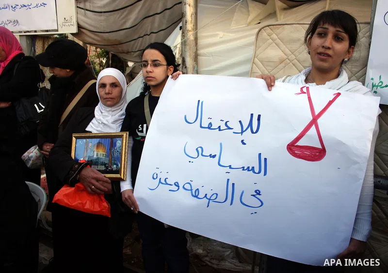 Palestinians hold pictures of their prisoned relatives in Israeli jails as they gather in a protest calling for their liberty in the West Bank city of Ramallah on March 26,2011. Photo by Issam Rimawi