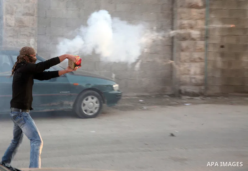 A Palestinian youth launches fireworks towards Israeli soldiers during clashes in the Shuafat Refugee Camp, north of Jerusalem 26 March 2011. Photo by Sliman Khader