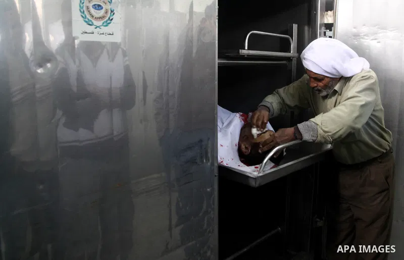 A Palestinian man cleans the body of one of the tow killed Palestinians, at the morgue in Kamal Adwan hospital in the town of Beit Lahiya, northern Gaza Strip, on March27 2011.