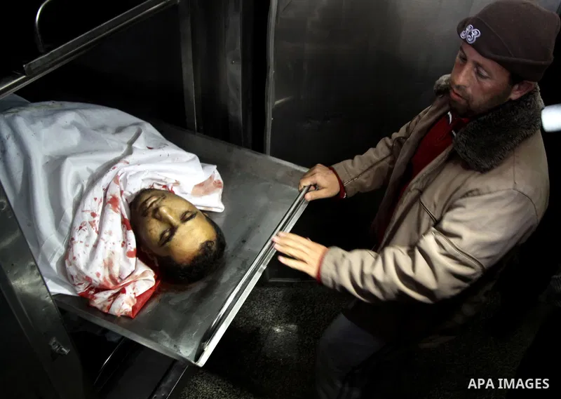 A Palestinian man cleans the body of one of the tow killed Palestinians, at the morgue in Kamal Adwan hospital in the town of Beit Lahiya, northern Gaza Strip, on March27 2011.