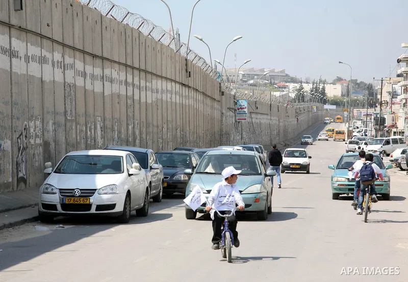 Palestinian children ride their bikes near the Israeli separation barrier during a festival under the title 'yes to life, yes to sports, no drug', in Al-Ram in the West Bank with the participation of the Directorate of E...