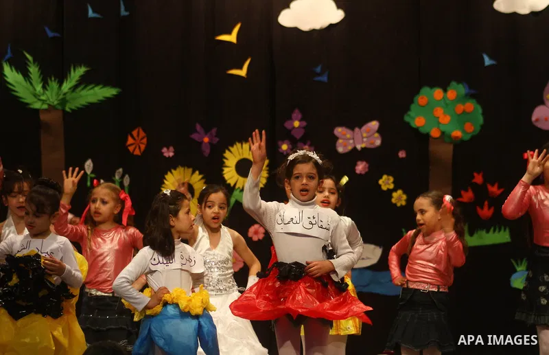Palestinian children dance during an entertaining celebration organized by UNRWA at Shawwa theatre in Gaza city on March 28,2011.. Photo by Ashraf Amra