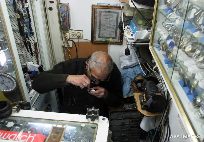 A Palestinian watches fixer repairs a watch at his shop in the market of the old city of Jerusalem on March 28,2011. Photo by Mahfouz Abu Turk