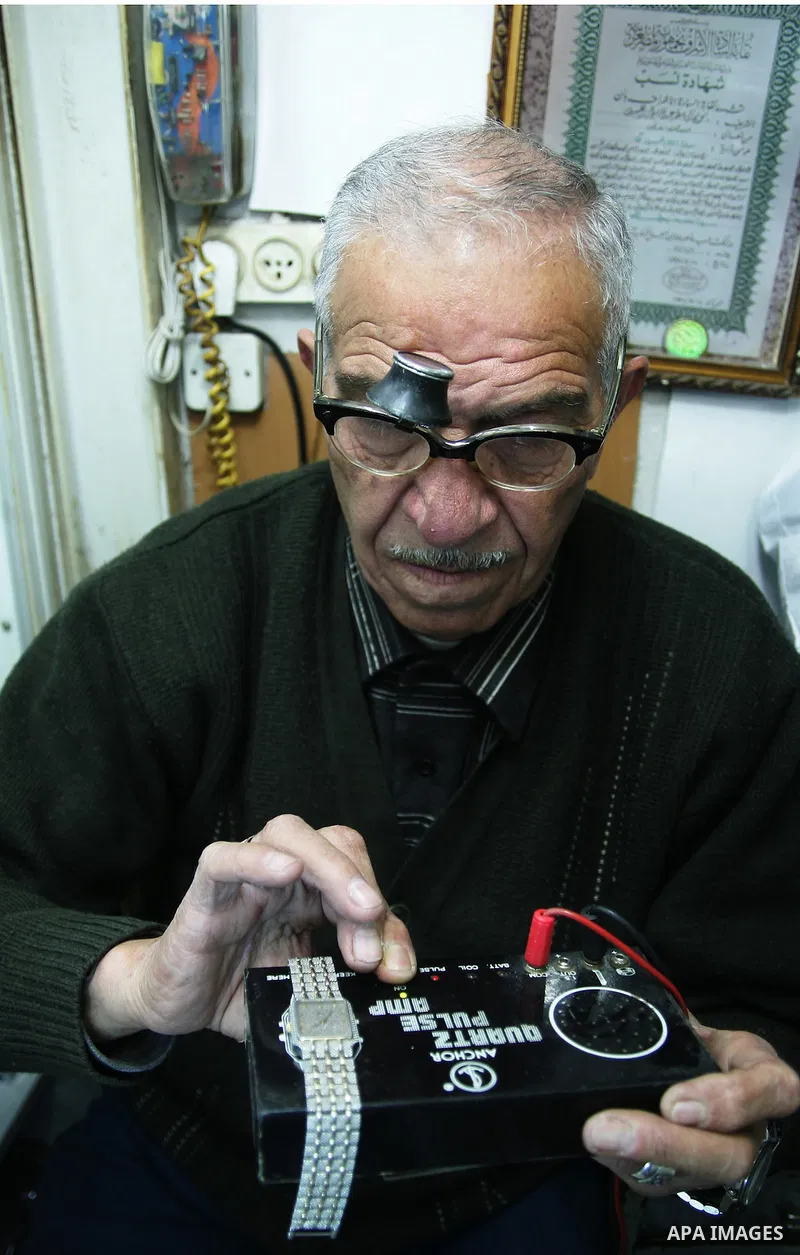 A Palestinian watches fixer repairs a watch at his shop in the market of the old city of Jerusalem on March 28,2011. Photo by Mahfouz Abu Turk