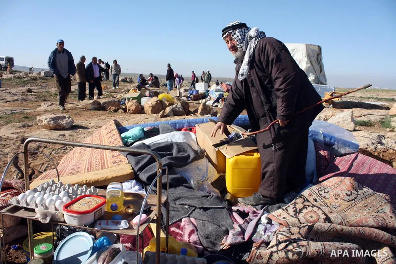 Palestinian family look for belongings from the rubble of their home after it was destroyed allegedly by Israeli army tractors early on 29 March 2011, in the West Bank village of Yatta near Hebron. The house was located...