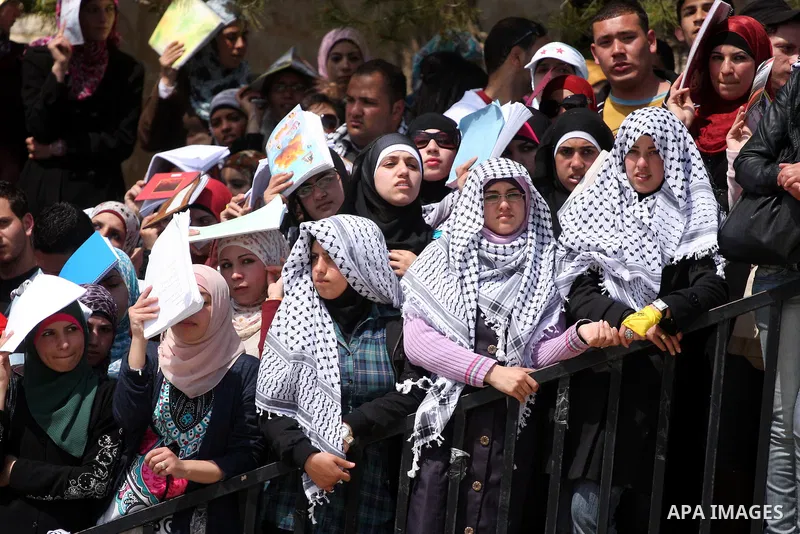 Palestinian students and Fatah supporters who loyal to the Palestinian President Mahmoud Abbas take part in Birzeit University Student Council elections campaign at the Birzeit University, in the West Bank city of Ramall...