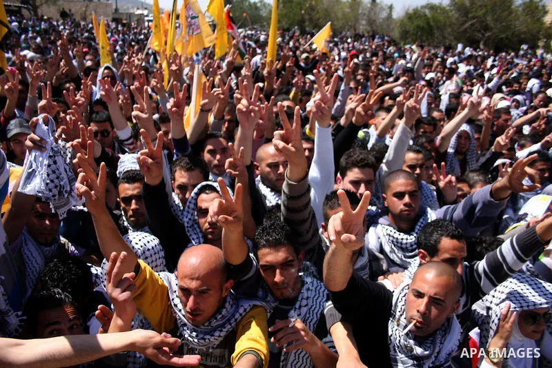 Palestinian students and Fatah supporters who loyal to the Palestinian President Mahmoud Abbas take part in Birzeit University Student Council elections campaign at the Birzeit University, in the West Bank city of Ramall...
