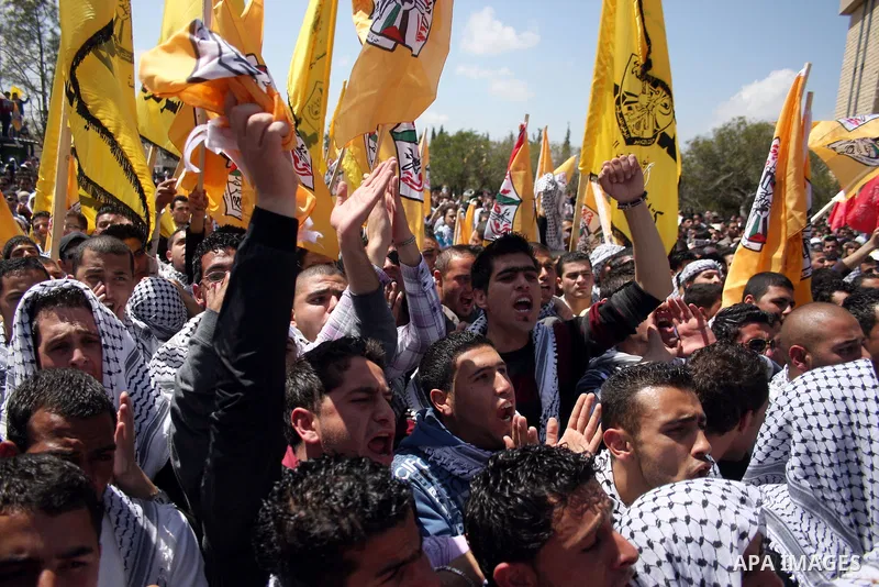 Palestinian students and Fatah supporters who loyal to the Palestinian President Mahmoud Abbas take part in Birzeit University Student Council elections campaign at the Birzeit University, in the West Bank city of Ramall...