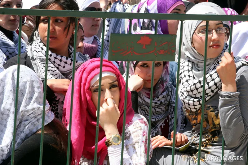 Palestinian students and Fatah supporters who loyal to the Palestinian President Mahmoud Abbas take part in Birzeit University Student Council elections campaign at the Birzeit University, in the West Bank city of Ramall...