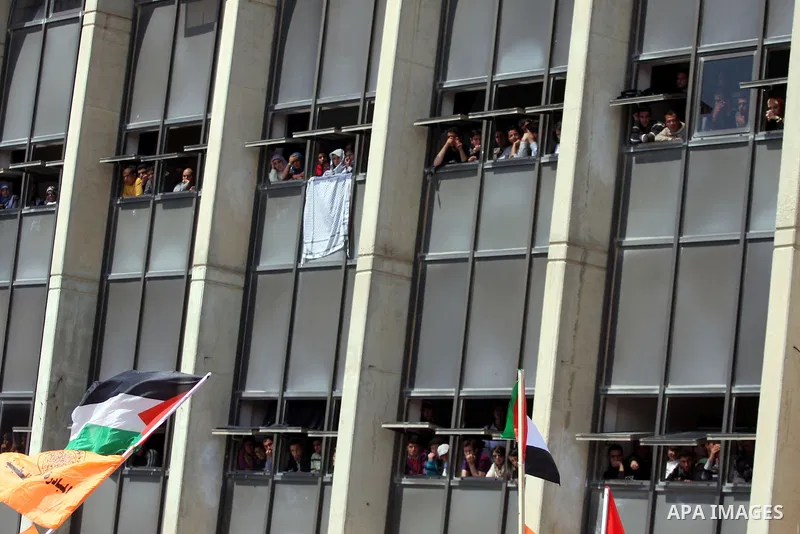 Palestinian students and Fatah supporters who loyal to the Palestinian President Mahmoud Abbas take part in Birzeit University Student Council elections campaign at the Birzeit University, in the West Bank city of Ramall...