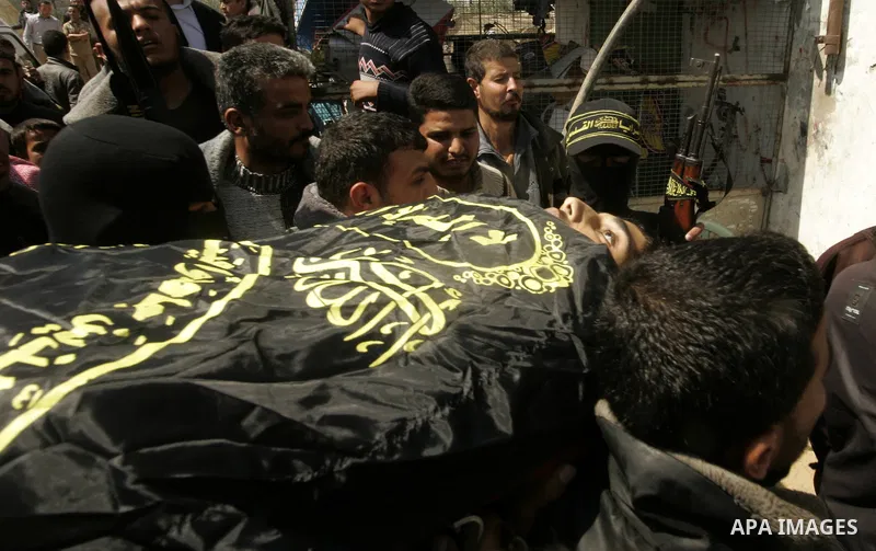 Palestinian militants from the Islamic Jihad carry the body of Mohammed Muammar, who was killed during an Israeli air strike the day, during his funeral southern Gaza Strip, on March 30, 2011. The raid killed Muammar and...