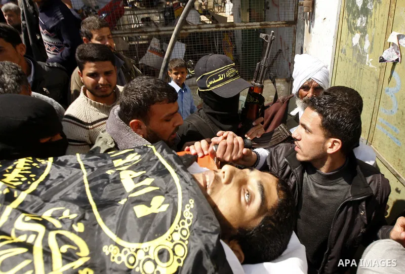 Palestinian militants from the Islamic Jihad carry the body of Mohammed Muammar, who was killed during an Israeli air strike the day, during his funeral, southern Gaza Strip, on March 30, 2011. The raid killed Muammar an...