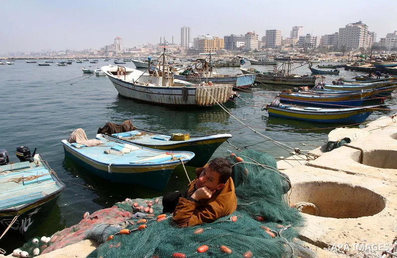 Palestinian fisherman fixes his fishing nets at the port in Gaza City 30, 2011. Israel is considering building an artificial island with sea and air ports off blockaded Gaza, as a long-term solution to shipping goods int...