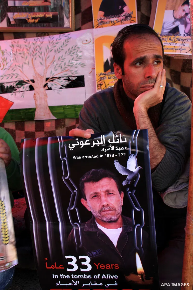 Palestinians man holds portraits of relatives, during a protest calling for the release of Palestinian prisoners from Israeli jails, in the West Bank city of Nablus , Thursday, March 31, 2011. Israel currently holds abou...