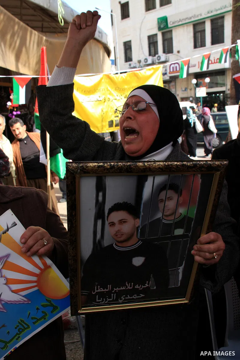 Palestinians man holds portraits of relatives, during a protest calling for the release of Palestinian prisoners from Israeli jails, in the West Bank city of Nablus , Thursday, March 31, 2011. Israel currently holds abou...
